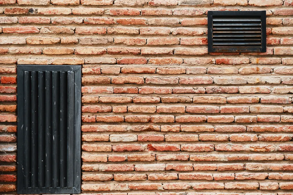 Grilles de ventilation sur un mur de briques : renouveler l'air limite la condensation dans les maisons d'Armentières et du Nord